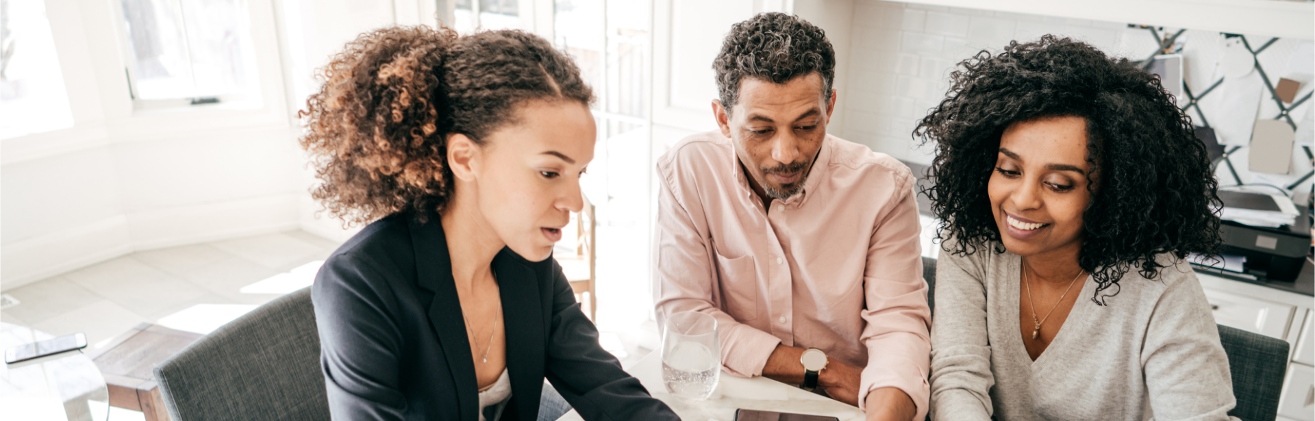 woman at desk with couple showing papers